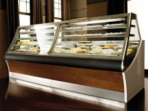 Sintesi with wood front laminate holding a variety of cakes in an empty windowed hall