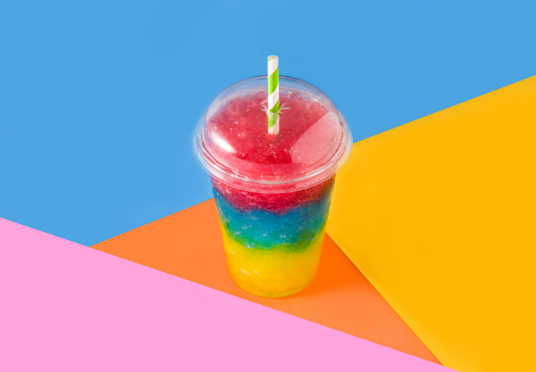 Adding a Slush Machine To Your Business - Multi colored slush drink with colorful triangle background